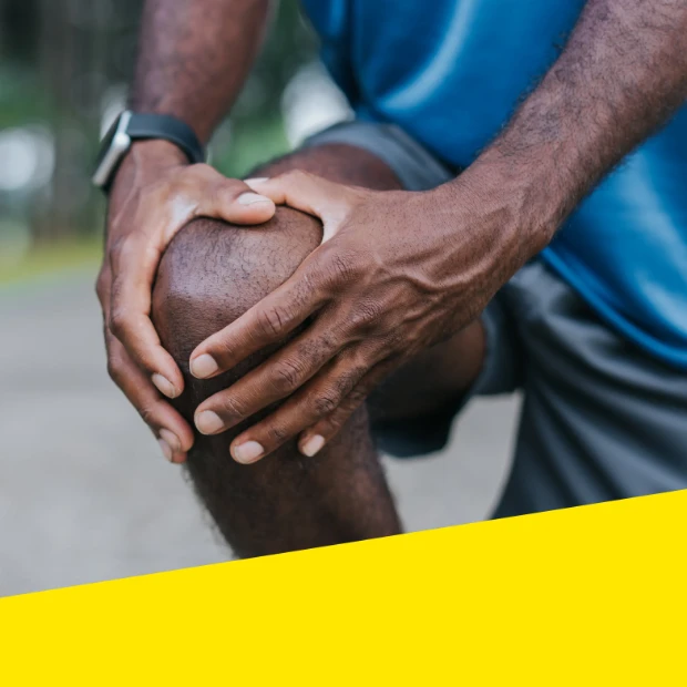 Man holds his knee due to discomfort or pain