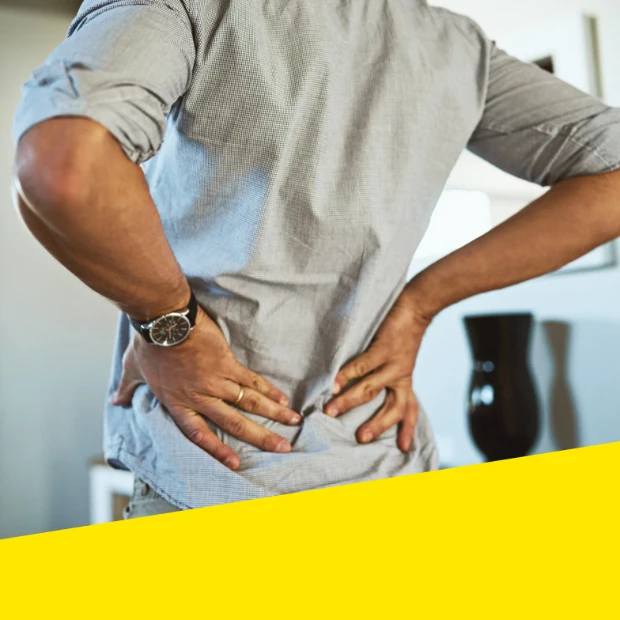 Man holds his lower back due to discomfort or pain