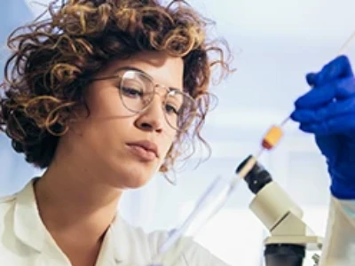 A scientist focusing on a tool in her lab.