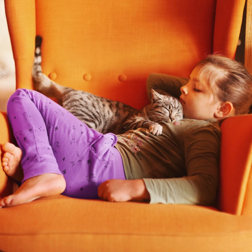 A woman sits on the floor next to her dog.